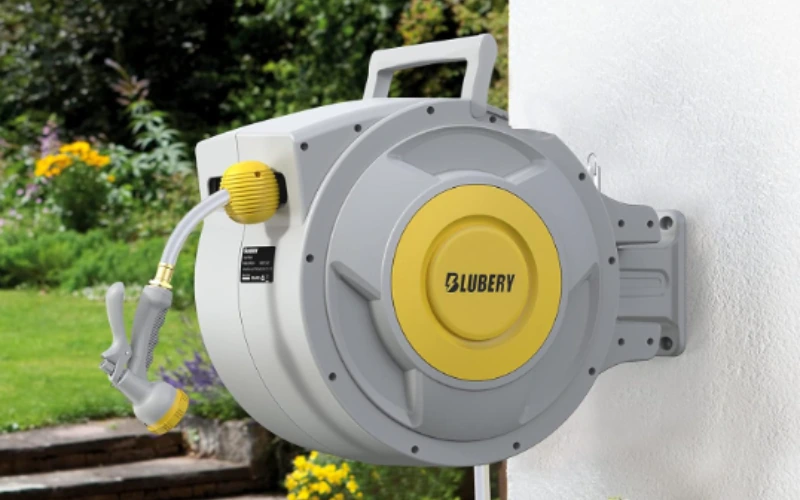 Wall-mounted retractable garden hose reel with a grey casing and yellow centre.